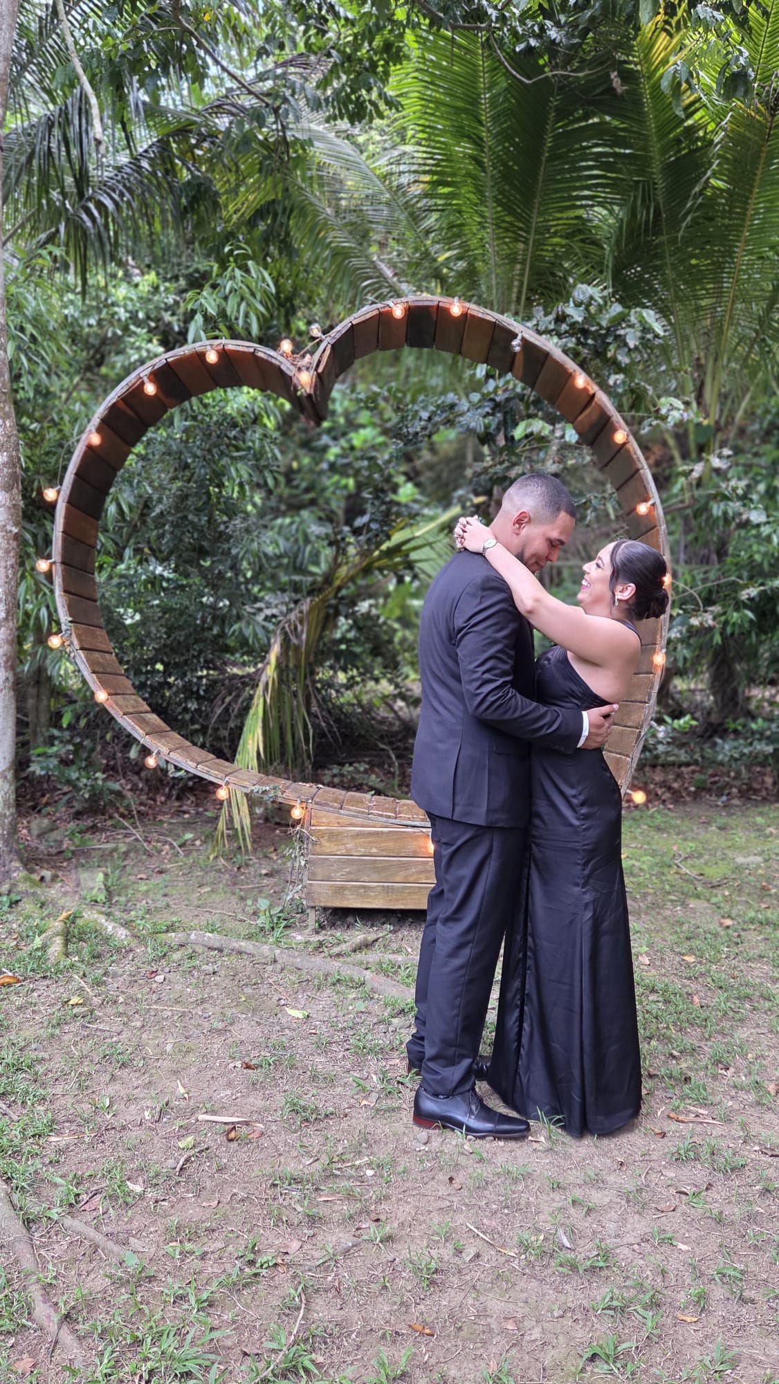 Mónica y Eric frente a un arco en forma de corazón